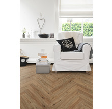 Woonkamer met visgraatparket, fauteuil en decoratieartikelen