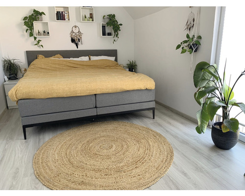 Slaapkamer met bed, tapijt en planten