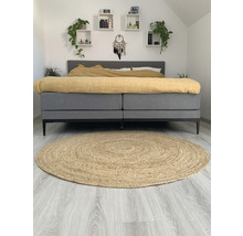 Slaapkamer met bed, planken en rond vloerkleed