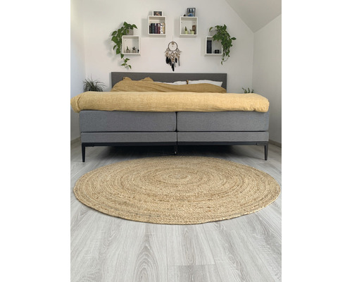 Slaapkamer met bed, planken en rond vloerkleed