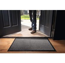 Deurmat voor een open voordeur op een houten vloer