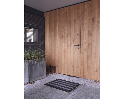 Entree met houten deur, deurmat en plantenbak