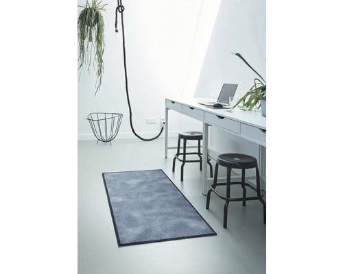 Lichte kamer met bureau, stoelen, lamp en rechthoekig vloerkleed