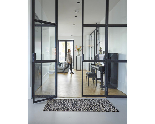 Interieur met glazen deuren, piano en tapijt met dierenprint