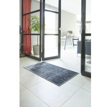 Decoratief tapijt in de hal van een huis op een tegelvloer.