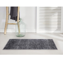 Grijs badmat voor muur met houten ladder en decoratieve fles