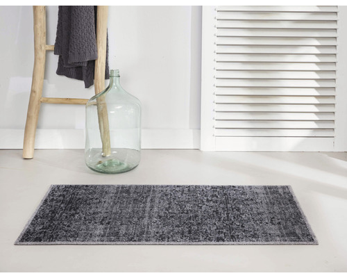 Grijs badmat voor muur met houten ladder en decoratieve fles