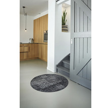 Interieur met rond vloerkleed, keuken en trap.