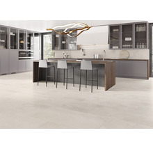 Lichte, moderne keuken met kookeiland, barkrukken en tegelvloer.