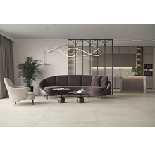 Lichte woonkamer met bank, fauteuil, tafel, kamerplant en kitchenette