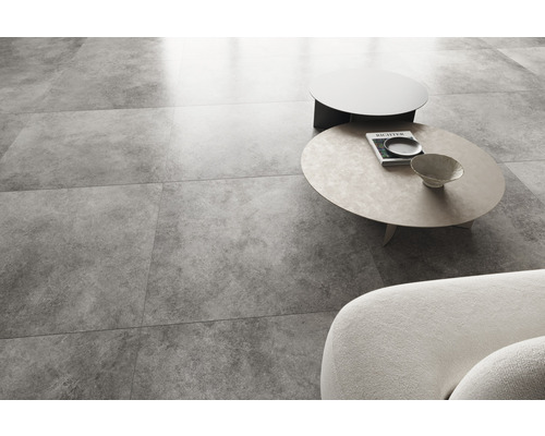 Lichte woonkamer met betonlook vloertegels, bank en salontafels