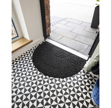 Halfronde deurmat van textiel voor een voordeur op een vloer met een geometrisch patroon