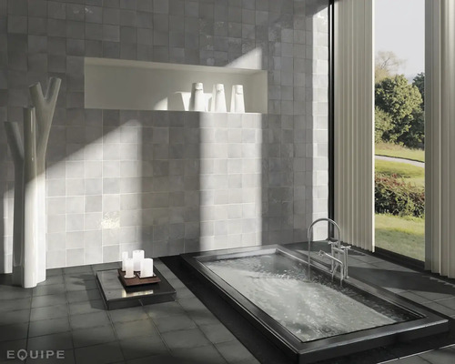 Moderne badkamer met bad, betegelde muur en decoratie