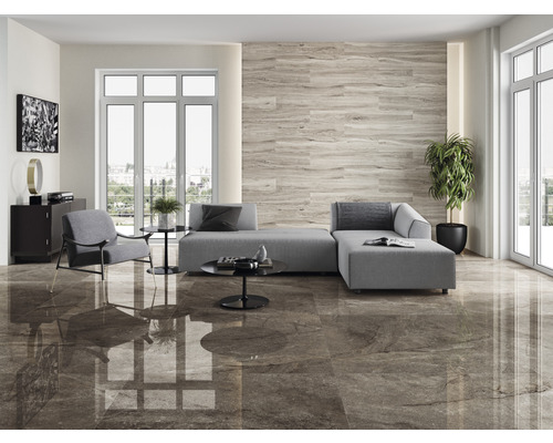 Lichte woonkamer met grijze bank, fauteuil en vloertegels in houtlook
