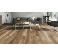 Woonkamer met laminaatvloer in houtlook, bruine bank en salontafels