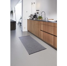Grijs vloerkleed in een keuken met houten kasten.