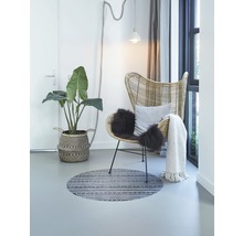 Lichte kameropstelling met rotan stoel, kamerplant, rond vloerkleed en decoratie