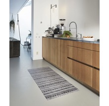 Keuken met houten kasten en een gestreept vloerkleed