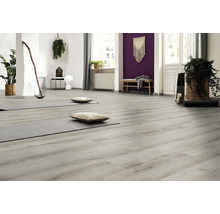 Lichte ruimte met grijze houten vloer, yogamatten en kussens