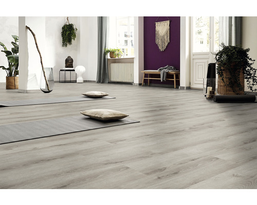 Lichte ruimte met grijze houten vloer, yogamatten en kussens