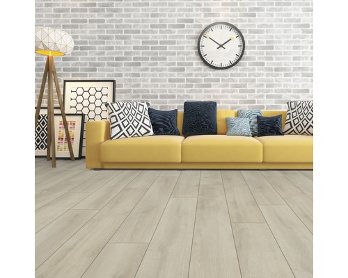 Woonkamer met lichte houten vloer, gele bank en decoratieve elementen zoals een klok en een staande lamp