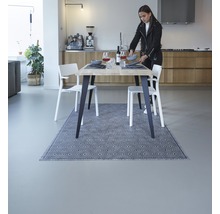 Eettafel met vloerkleed in een lichte eetkamer met stoelen en decoratie