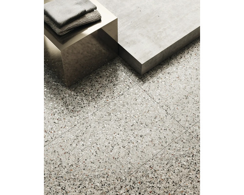Interieurbeeld met terrazzo vloertegels, een metalen tafel en handdoeken