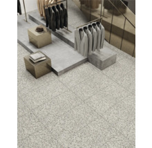 Interieurweergave met vloertegels in terrazzo-look, kledingrekken en verkoopdisplays.