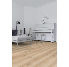Woonkamer met lichte houten vloer, bank, gitaren en piano