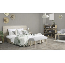 Lichte slaapkamer met bed, houten rek en bank