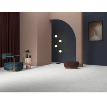 Lichte ruimte met tegelvloer, fauteuil, lamp en decoratie