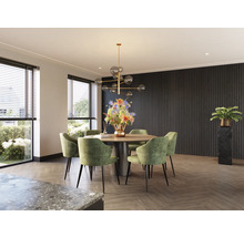 Eetkamer met ronde tafel, groene stoelen en decoratieve verlichting