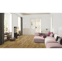 Woonkamer met houten vloer, kachel en roze bank