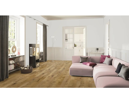 Woonkamer met houten vloer, kachel en roze bank