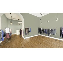 Interieur van een kledingwinkel met kledingrekken en houten vloer