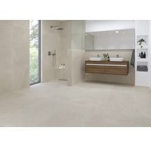 Lichte badkamer met douche, wastafel en grootformaat tegels.