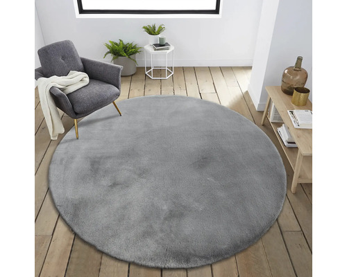 Interieurscène met rond, grijs tapijt, fauteuil en bijzettafel