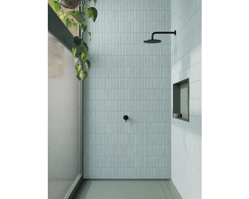 Moderne doucheruimte met smalle, verticale tegels, douchekop en ingebouwde plank