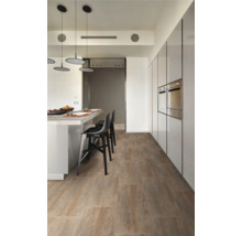 Lichte kamer met houten vloer, toonbank en kitchenette.