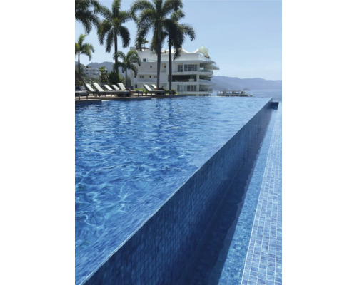 Zwembad met mozaïektegels en infinity pool design, omgeven door palmbomen en een gebouw