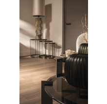 Lichte woonkamer met staande lamp, bijzettafels en decoratieve vazen op een salontafel