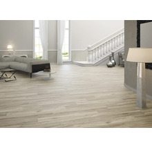 Lichte woonkamer met bank, trap en houtlook tegels