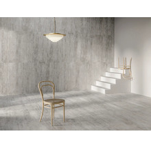 Interieur met grijs gemêleerde tegels, een hanglamp, een stoel en een trap