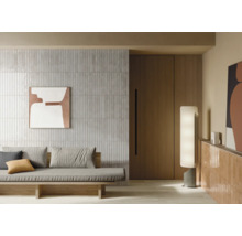 Woonkamer met betegelde wand, sofa en decoratieve verlichting voor een moderne sfeer.