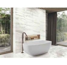 Badkamer met bad, kraan en wandtegels in marmerlook