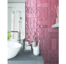 Badkamer met wastafel, douche en wandtegels in baksteenlook