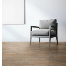 Lichte ruimte met vloertegels, fauteuil en een schilderij aan de muur