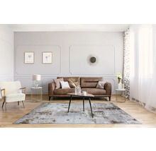 Woonkamer met bruine bank, vloerkleed, fauteuil en tafel