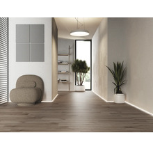 Licht interieur met akoestische panelen, fauteuil en potplanten op een houten vloer.