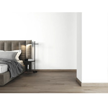 Slaapkamer met bed, nachtkastje en vloerlamp
